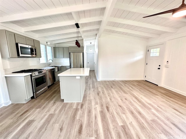 kitchen with light hardwood / wood-style flooring, stainless steel appliances, a center island, decorative light fixtures, and gray cabinets