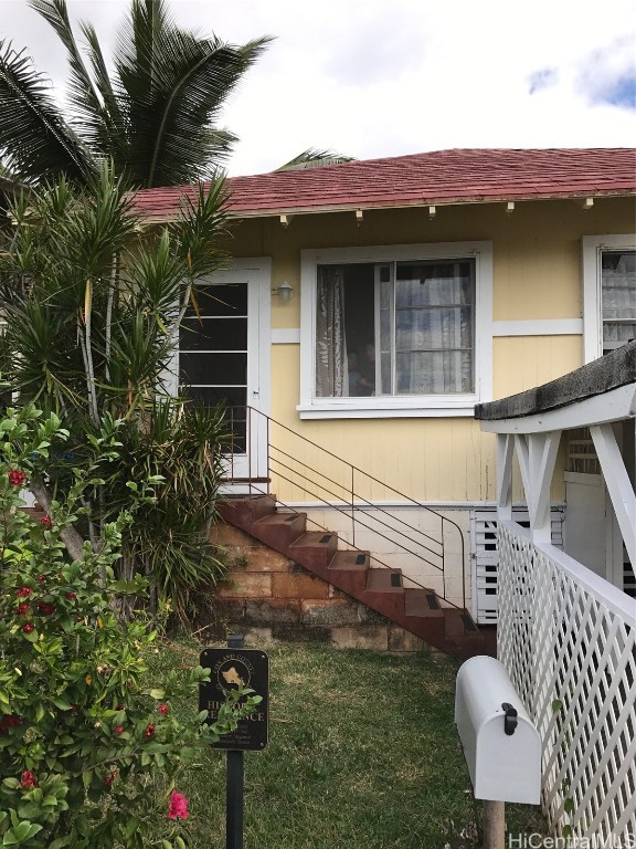 doorway to property with a lawn