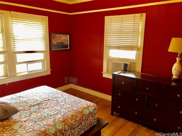 bedroom featuring ornamental molding and light wood-type flooring