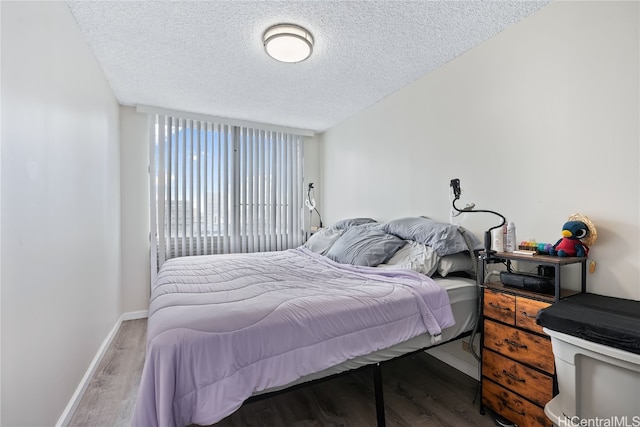 bedroom featuring wood-type flooring and a textured ceiling