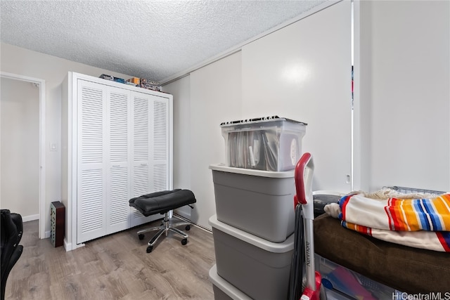 miscellaneous room featuring light hardwood / wood-style floors and a textured ceiling