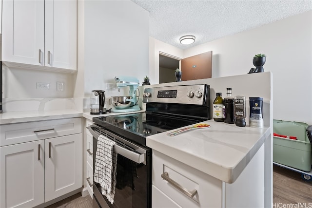 kitchen featuring light stone countertops, stainless steel range with electric stovetop, a textured ceiling, white cabinetry, and light hardwood / wood-style floors