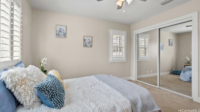 carpeted bedroom with ceiling fan and a closet