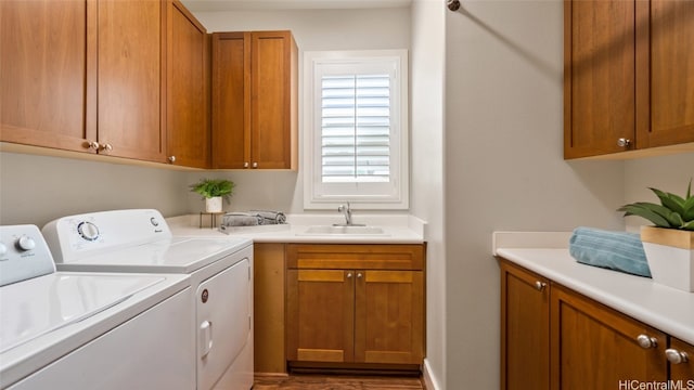 clothes washing area featuring separate washer and dryer, sink, cabinets, and wood-type flooring