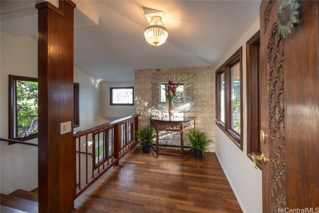 hall featuring a notable chandelier, vaulted ceiling, and dark hardwood / wood-style floors