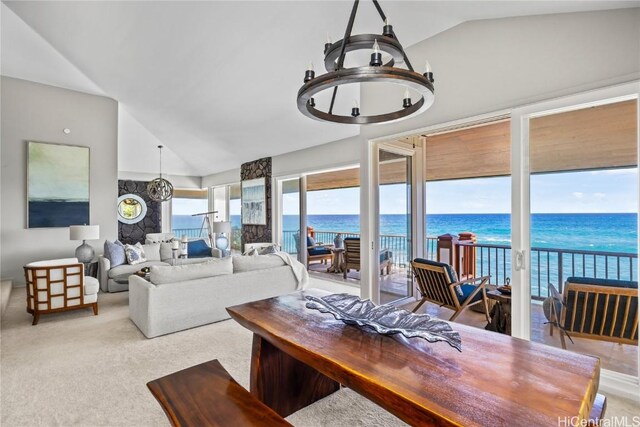 living room featuring high vaulted ceiling, a notable chandelier, and a water view