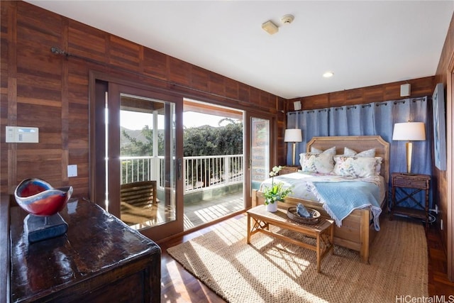 bedroom with access to exterior and wooden walls