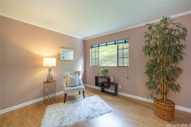 living area with light hardwood / wood-style floors and crown molding