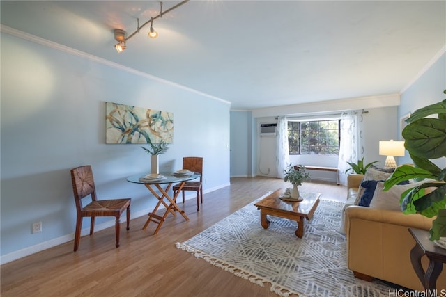 living room featuring ornamental molding, light hardwood / wood-style floors, and a wall mounted air conditioner