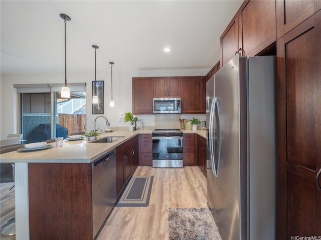 84-883 Maiola St Unit 118, Waianae, HI 96792 - kitchen featuring appliances with stainless steel finishes, light wood-style flooring, a peninsula, pendant lighting, and decorative backsplash
