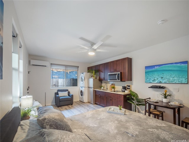 84-883 Maiola St Unit 118, Waianae, HI 96792 - dining room with stacked washing machine and dryer, a wall unit AC, light wood-style floors, and ceiling fan