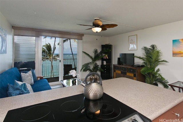 kitchen with open floor plan, light countertops, a ceiling fan, and stovetop