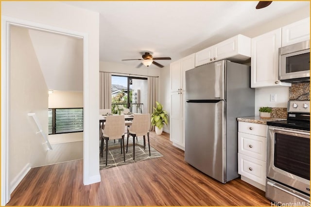 kitchen featuring white cabinetry, ceiling fan, light stone countertops, dark hardwood / wood-style floors, and appliances with stainless steel finishes