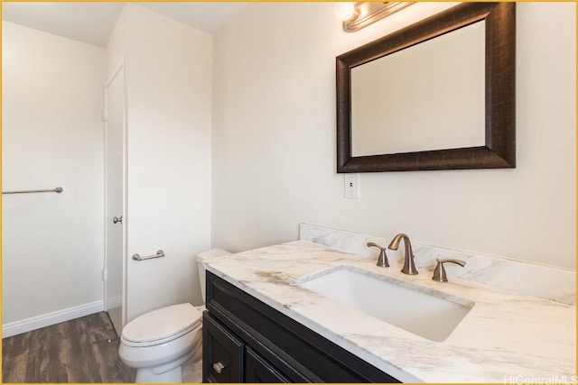 bathroom with hardwood / wood-style floors, vanity, and toilet