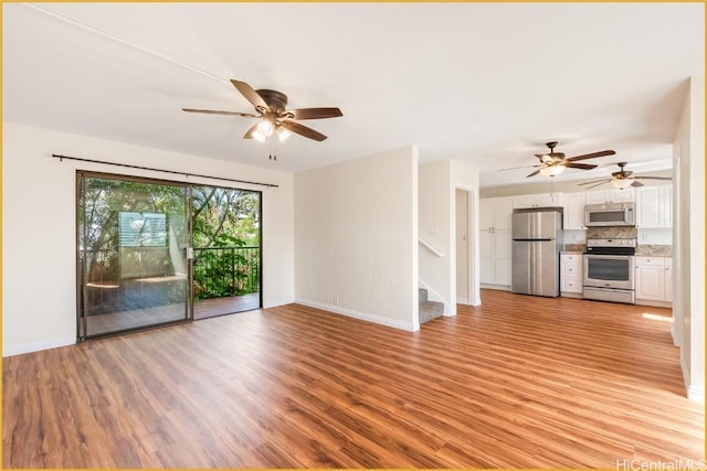 unfurnished living room featuring ceiling fan and light wood-type flooring