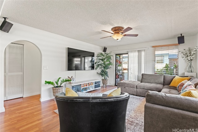 living room with hardwood / wood-style floors, ceiling fan, and a textured ceiling