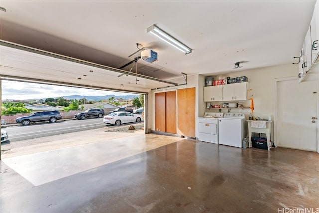 garage with a mountain view, independent washer and dryer, a garage door opener, and sink