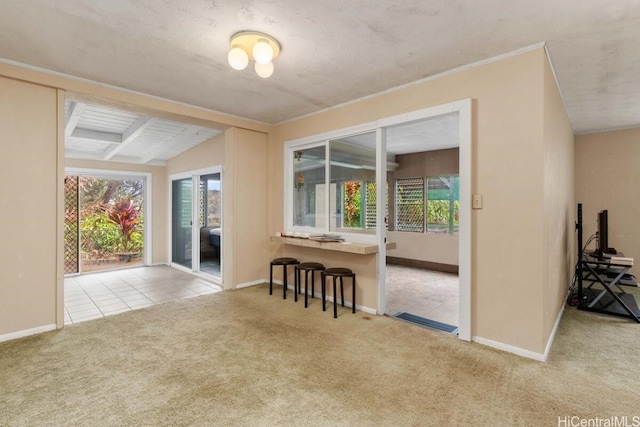 empty room featuring a textured ceiling, vaulted ceiling with beams, and light colored carpet