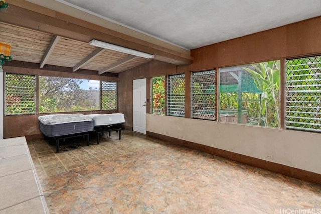 sunroom / solarium featuring lofted ceiling with beams