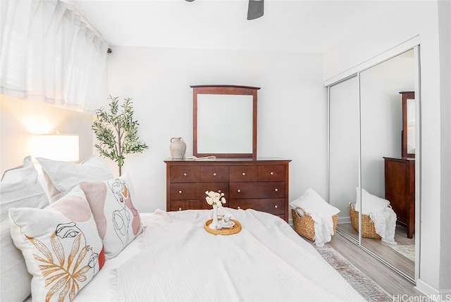 bedroom with light wood-type flooring, a closet, and ceiling fan