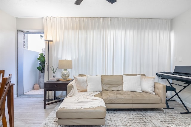 living room with light hardwood / wood-style flooring and ceiling fan