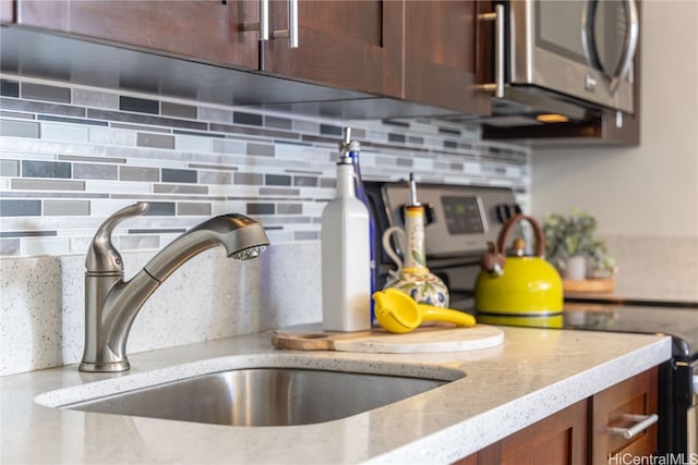 room details with light stone countertops, sink, and tasteful backsplash