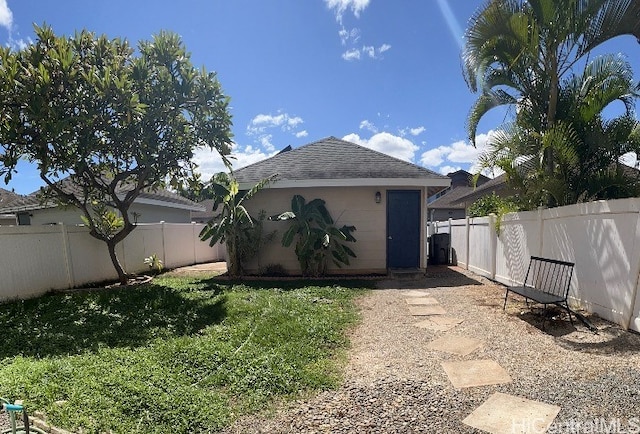 rear view of property featuring an outbuilding and a lawn