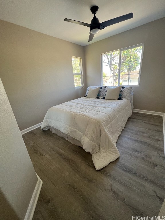 bedroom with dark hardwood / wood-style flooring and ceiling fan