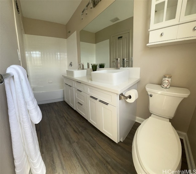 full bathroom with wood-type flooring, shower / bathing tub combination, vanity, and toilet