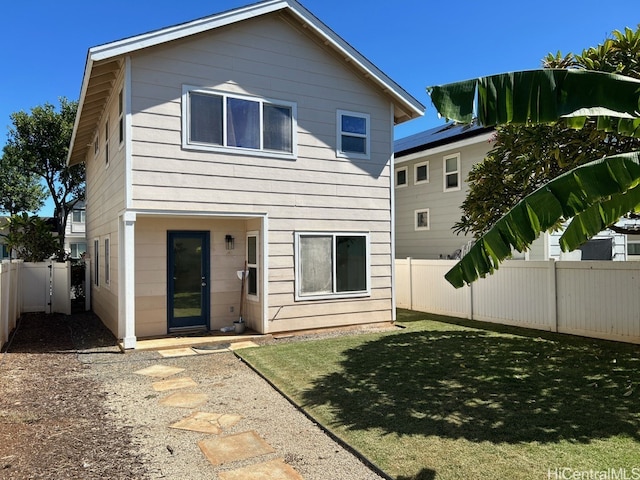 rear view of property with a lawn