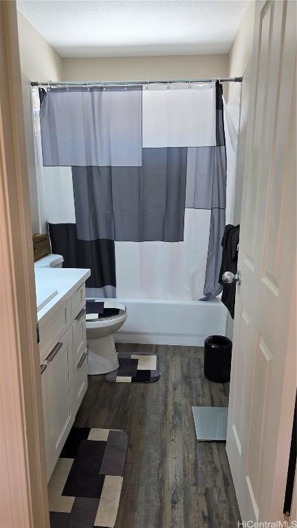 full bathroom featuring vanity, wood-type flooring, toilet, and shower / bathtub combination with curtain