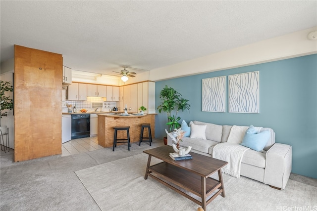 living room with light carpet, a textured ceiling, and ceiling fan