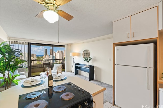 kitchen with white cabinetry, a textured ceiling, ceiling fan, and white refrigerator