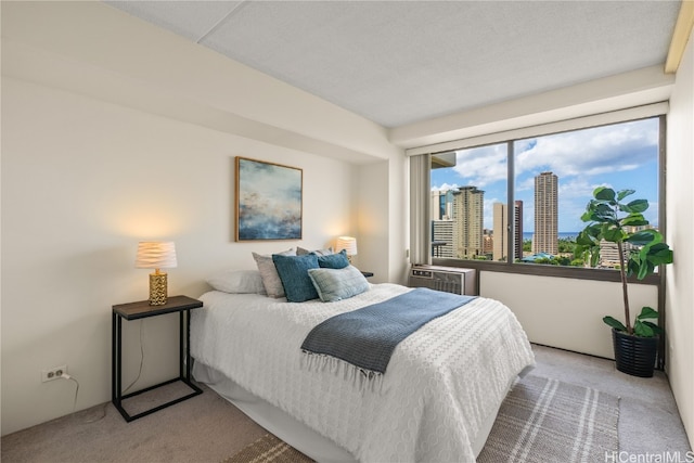 carpeted bedroom with a wall mounted AC and a textured ceiling