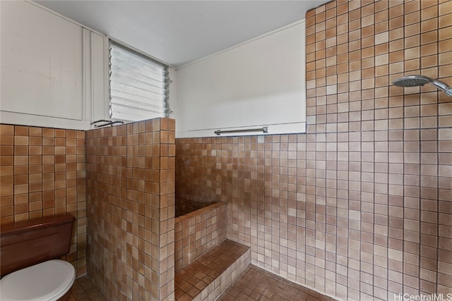 bathroom with toilet, tile walls, tile patterned flooring, and walk in shower