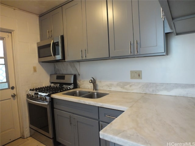 kitchen featuring gray cabinets, sink, stainless steel appliances, and tasteful backsplash