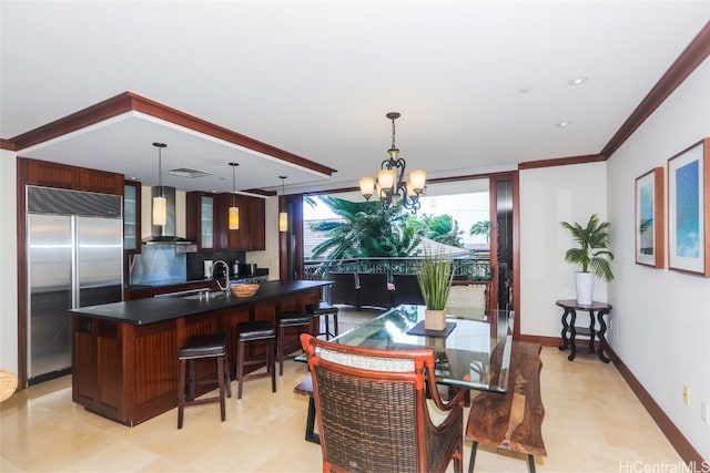 dining area featuring a notable chandelier, ornamental molding, and sink