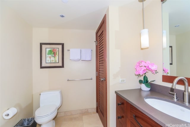 bathroom with toilet, vanity, and tile patterned flooring