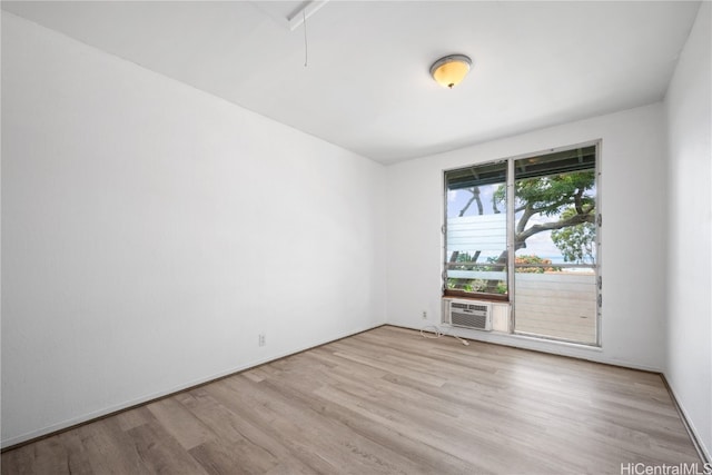 unfurnished room featuring cooling unit and light wood-type flooring