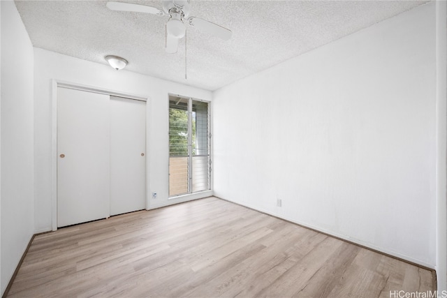 unfurnished bedroom featuring a closet, a textured ceiling, light wood-type flooring, and ceiling fan