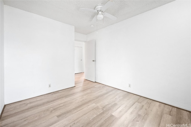 unfurnished room featuring a textured ceiling, light wood-type flooring, and ceiling fan