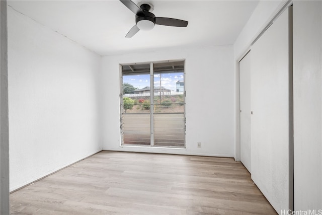 unfurnished bedroom with light wood-style flooring, ceiling fan, and a closet