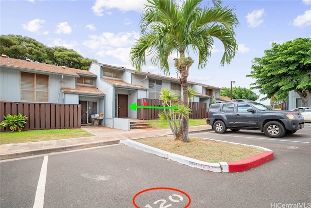 view of front of property featuring uncovered parking and fence