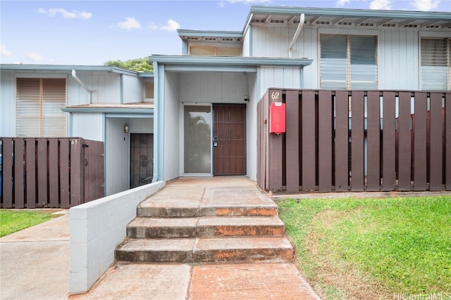 doorway to property featuring fence