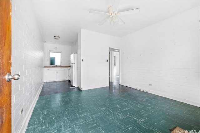 interior space with sink, brick wall, and ceiling fan