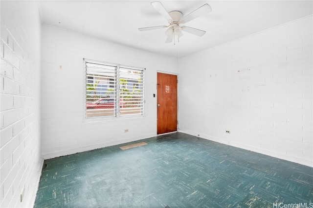 unfurnished room with brick wall and ceiling fan