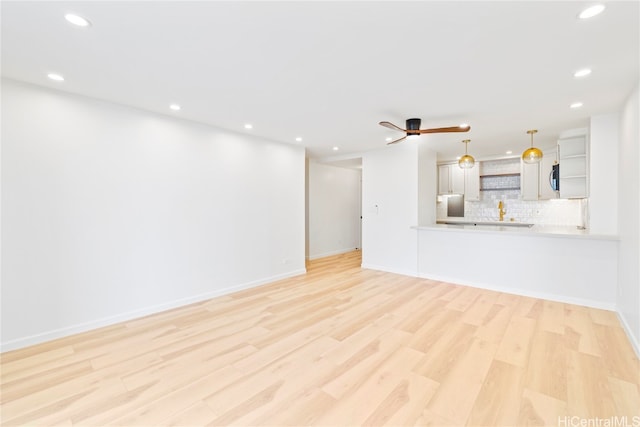 unfurnished living room featuring light hardwood / wood-style floors and ceiling fan