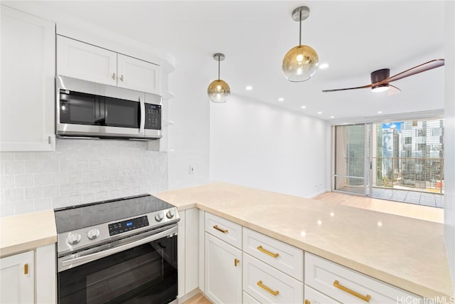 kitchen with white cabinets, hanging light fixtures, stainless steel appliances, and tasteful backsplash