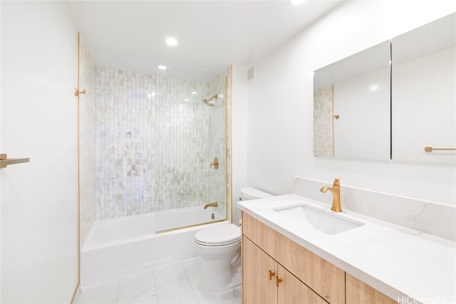 full bathroom featuring tiled shower / bath, vanity, and toilet