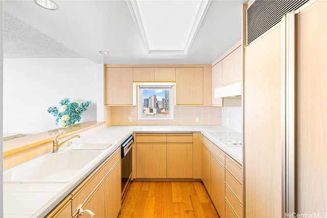 kitchen featuring black dishwasher, light wood-type flooring, paneled built in fridge, extractor fan, and light brown cabinets